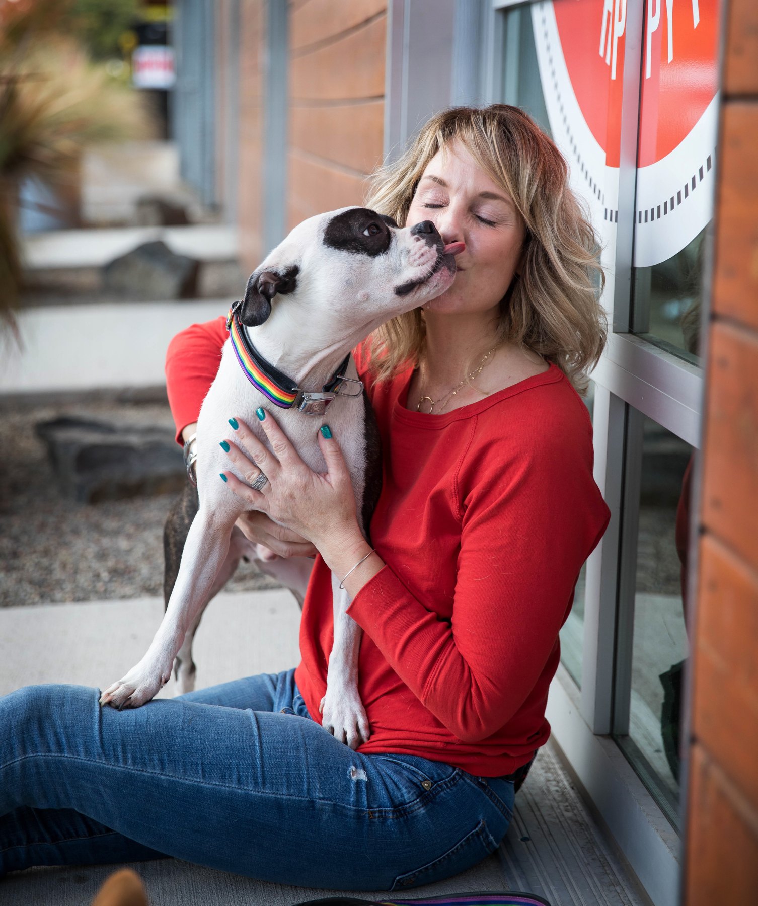 Jen sharing a relaxed moment with a white dog outside Training Spot